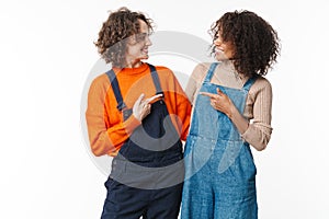 Portrait of two happy women hugging and pointing fingers at each other