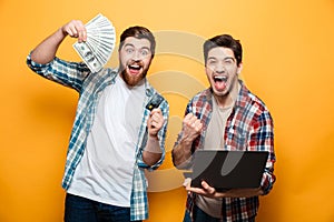 Portrait of a two happy young men holding laptop