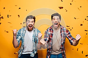 Portrait of a two happy young men holding rugby ball