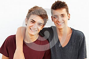 Portrait Of Two Hispanic Teenage Boys Leaning Against Wall