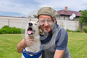 Portrait of two homeless fiends - dirty mature man and cute mixed breed dog that both are happy