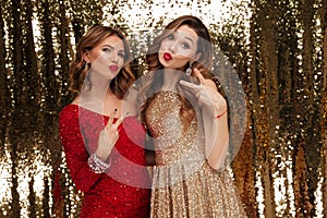 Portrait of two joyful happy women in sparkly dresses