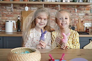 Portrait of two little girls with Easter rabbits on their fingers