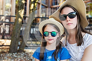 Portrait of two little girls in hats and sunglasses