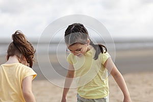 Portrait of two little girls playing on the beach at the day time