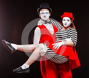 Portrait of two mime artists, isolated on black background. Man holds woman in his arms. Symbol of happy marriage, sweet