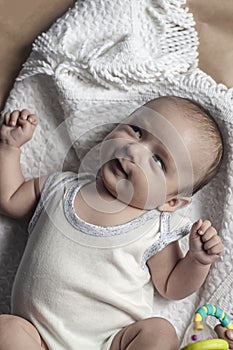 Portrait of two months baby boy looking cheerfully. View from above. Flat lay photo. Emotional expressions