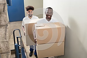 Portrait Of Two Movers Holding Cardboard Boxes