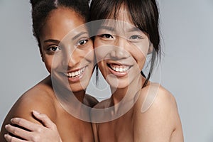 Portrait of two multinational half-naked women hugging and laughing