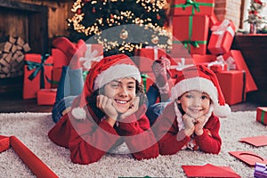 Portrait of two nice attractive cheerful people siblings lying on carpet resting eve festal occasion at home indoors