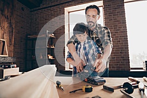 Portrait of two nice person concentrated focused creative hard-working woodworkers master handymen dad teaching son old