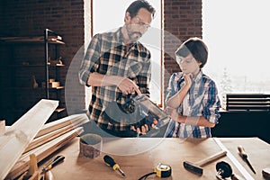 Portrait of two nice person focused creative woodworkers master handymen dad teaching explaining son old-fashioned