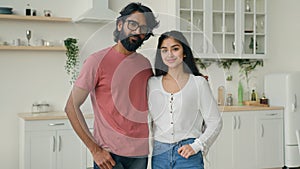 Portrait of two people multiracial couple in love posing in domestic white kitchen. Arabian hispanic indian ethnic