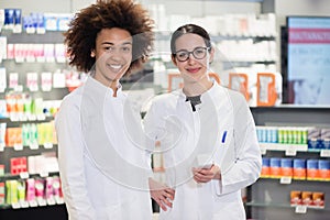 Portrait of two pharmacists smiling with confidence at work