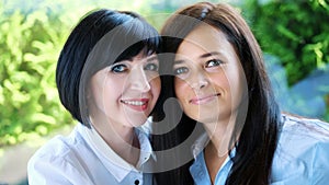 Portrait of two pleasant smiling, beautiful real 40 years old women. Happy middle aged friends meeting