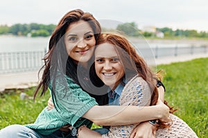 Portrait of two pretty girl friends smiling hugs and having fun