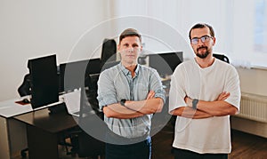 Portrait of two professional male programmers working on computer in diverse offices. Modern IT technologies