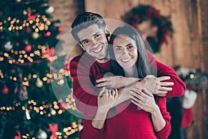 Portrait of two romantic lovely people hug near christmas tree in the morning enjoying christmas vacation in house with
