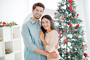 Portrait of two romantic people cheerful man and woman cuddle hug enjoy christmas time x-mas holidays in house with