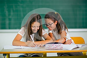 Portrait of two schoolgirls in a classroom.