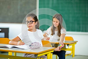 Portrait of two schoolgirls in a classroom.