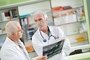 Portrait two senior doctors examining x-ray