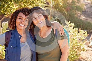 Portrait Of Two Senior Female Friends Hiking Along Trail In Countryside Together