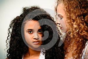 Portrait of two curly girls. Afro and blond