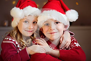 Portrait of two siblings in red Santa's hats