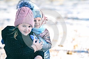 Portrait of two sisters of different ages on a winter walk in a snowy park