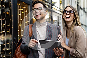 Portrait of two smiling business people walking and talking together in urban background