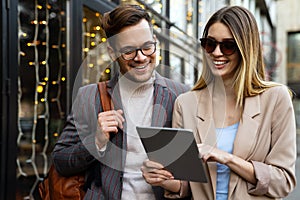 Portrait of two smiling business people walking and talking together in urban background