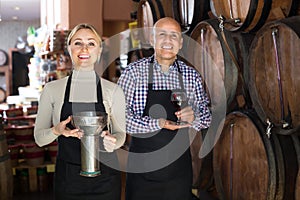 Portrait of two smiling wine makers taking wine