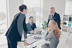 Portrait of two stylish business persons in suits having disagreement, war, conflict, standing near desktop in front of each photo