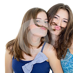 Portrait of a two teen girls have fun and make faces with moustache made of hair pigtail