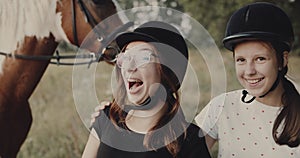 Portrait of two teen girls near the horse, pretty jokey girls
