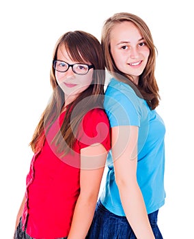 Portrait of two teen girls standing back-to-back