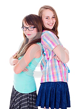 Portrait of two teen girls standing back-to-back