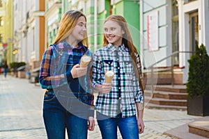 Portrait of two teenager girls standing together eating ice cream