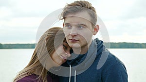 Portrait of two teenagers, a guy and a girl, against the background of a river and forest.