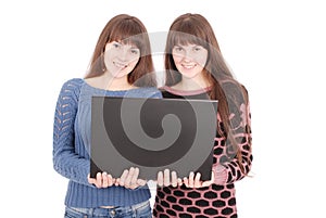 Portrait of two twins sisters with laptop