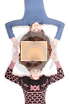 Portrait of two twins sisters with long hair and cork board