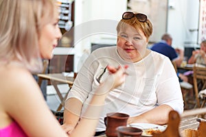 Portrait of two women, a mother and her daughter sitting in a cafe