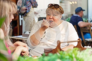 Portrait of two women, a mother and her daughter sitting in a cafe