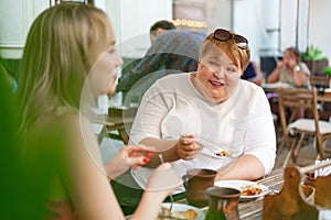 Portrait of two women, a mother and her daughter sitting in a cafe