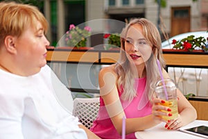 Portrait of two women, a mother and her daughter sitting in a cafe