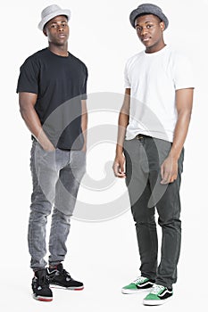 Portrait of two young African American men in casuals over gray background