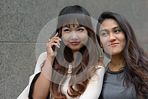 Portrait of two young Asian businesswomen together in the city