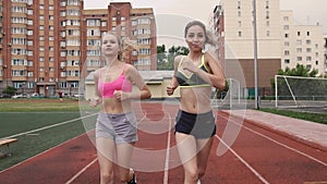 Portrait of two young athletes who compete in the race at the stadium in the morning, summer, outdoors