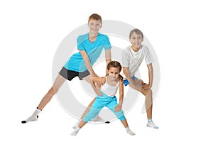 Portrait of two young boys brothers and little sister exercising isolated on white background